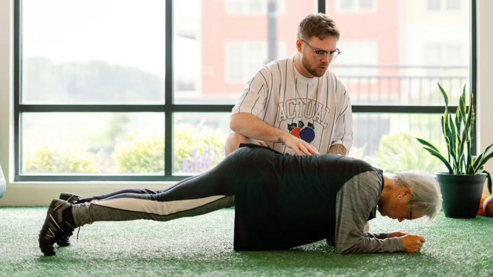 A personal training working with a client that is doing a plank exercise.