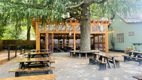 A gravel yard with benches and a covered seating area.