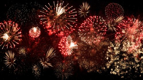 A black sky with red and gold firework bursts.