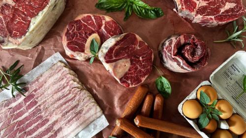 An multi-product display of meat, sausage, and eggs.