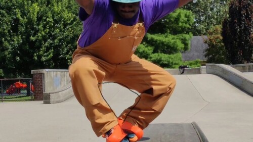 A man wearing rollerblades skates in a park.