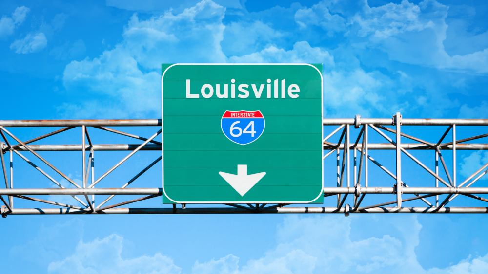 Green road sign with Interstate 64 symbol against a blue sky.