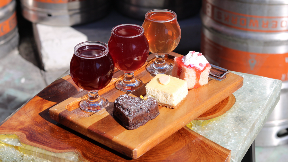 Three glasses of hard cider from Bivouac paired with three mini desserts — a cheesecake, a strawberry cake, and chocolate tart.