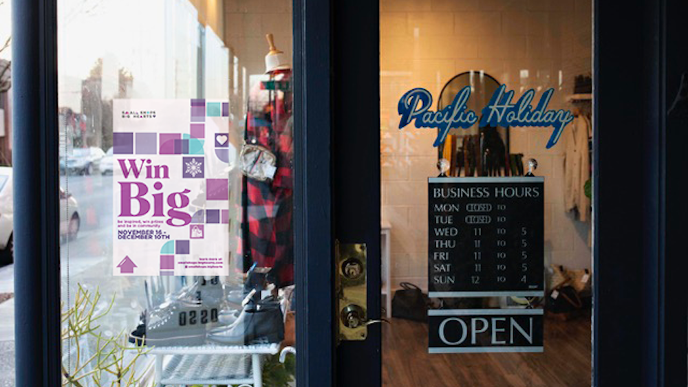 A storefront for Pacific Holiday in Portland shows a poster for Win Big.