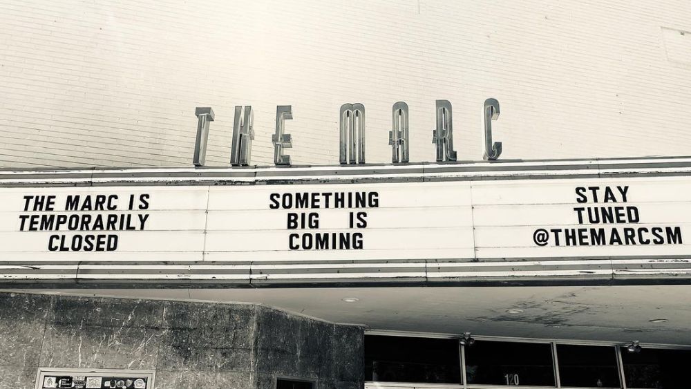 Black and white image of The Marc music venue in San Marcos, Texas. The words on the signage read "The Marc is temporarily closed, something big is coming, stay tuned @themarcsm."