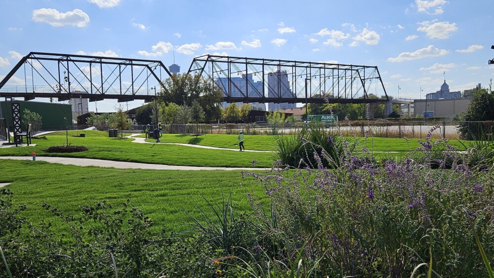Green grass covers the lawn of the latest skate park in San Antonio with downtown views.