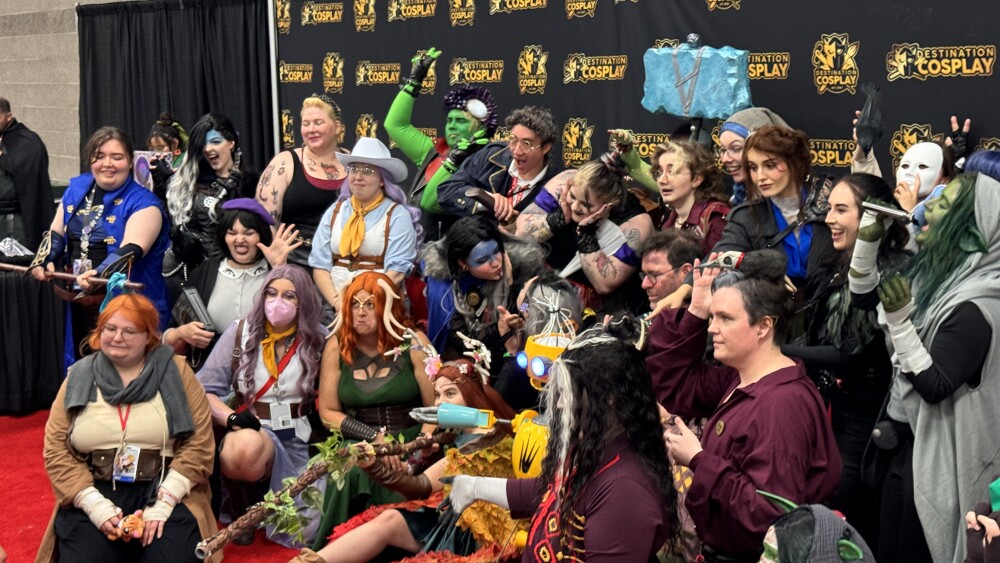 Around two dozen people in costumes pose for a photo at Rose City Comic Con.