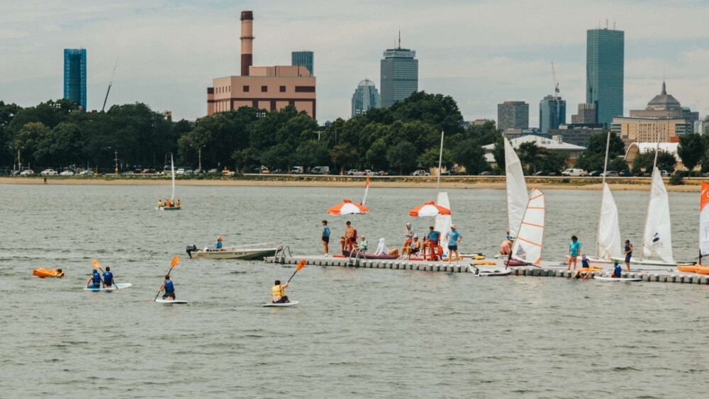 Boston skyline + people on a dock in the water