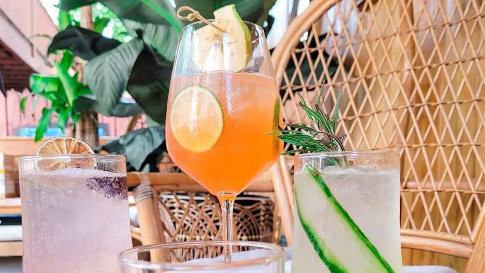 Four drinks in various colors like pink, orange, tan, and light green.