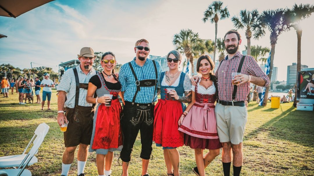 People in traditional German outfits pose with their brews on the St. Pete Pier.