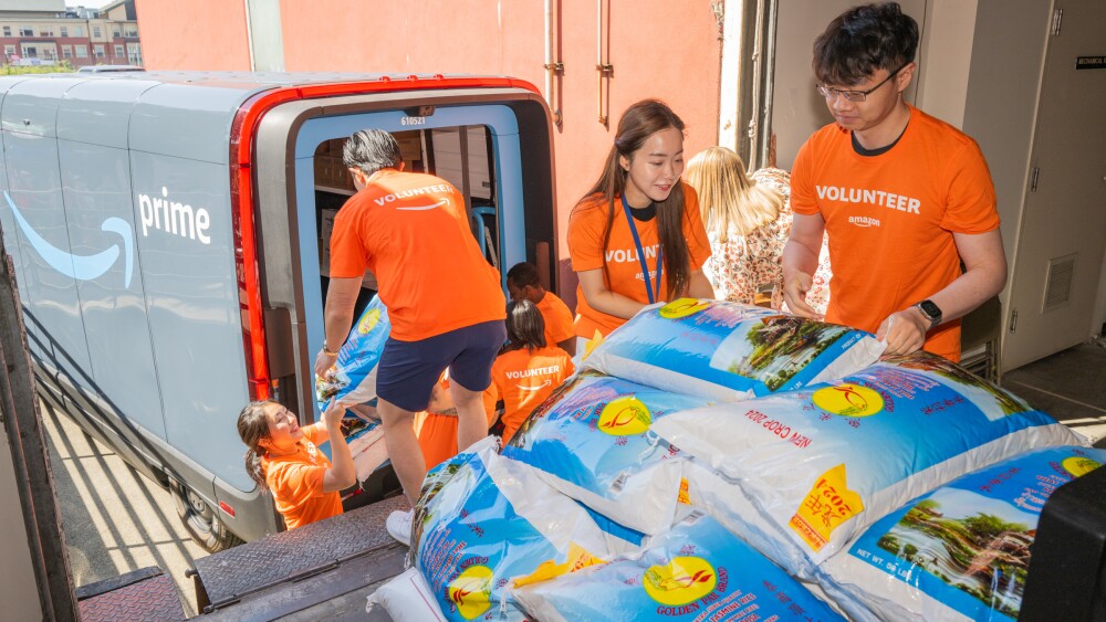 A group of Amazon volunteers unload bags of donated rice at the Asian Counseling & Referral Service’s (ACRS) Food Bank in the Chinatown-International District.